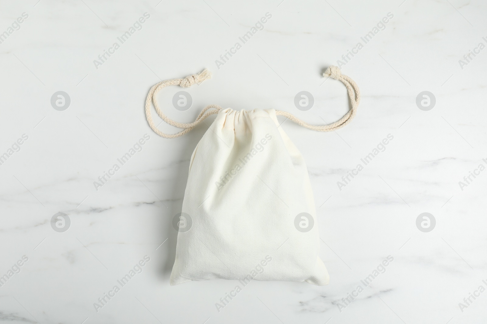 Photo of One cotton bag on white marble table, top view