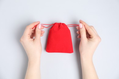 Woman with red cotton bag on light background, top view