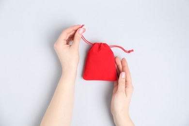 Photo of Woman with red cotton bag on light background, top view