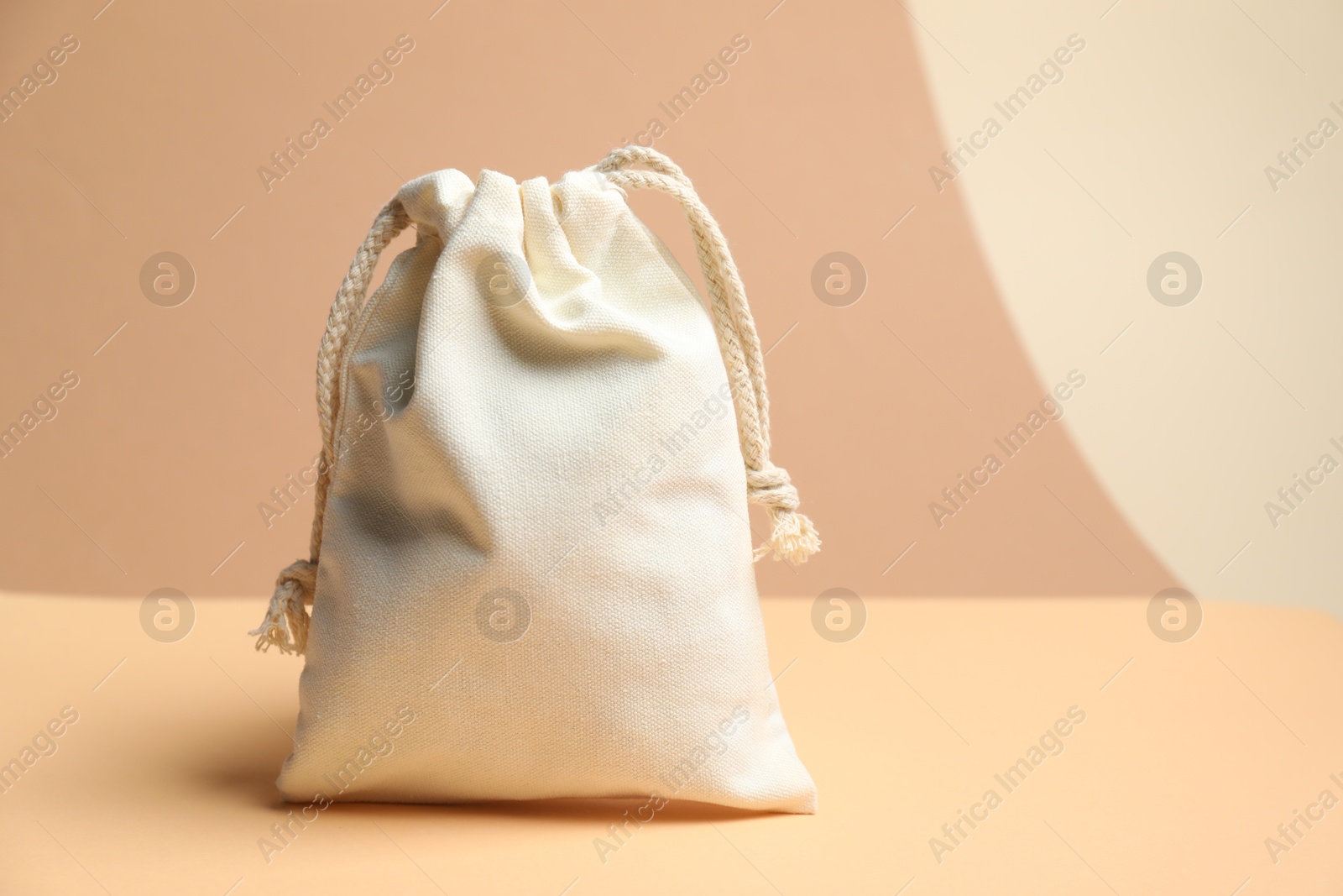 Photo of One burlap bag on table against beige background, space for text