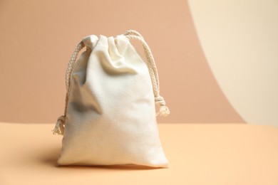 Photo of One burlap bag on table against beige background, space for text