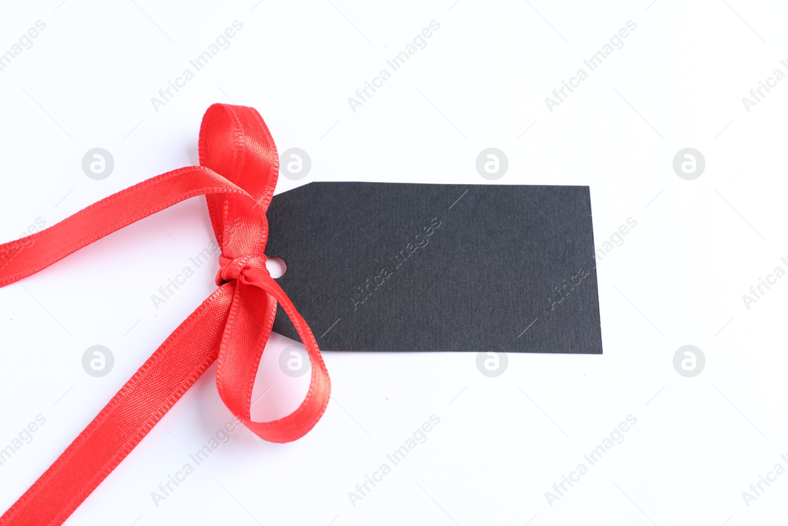 Photo of Blank tag with ribbon bow isolated on white