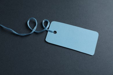 Photo of Blank tag with string on grey background, closeup