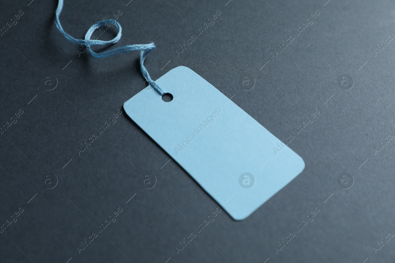 Photo of Blank tag with string on grey background, closeup