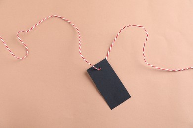 Photo of Blank tag with string on beige background, top view