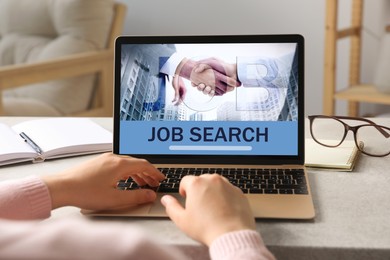 Image of Woman looking for job using employment website on laptop at home, closeup