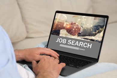 Image of Man looking for job using employment website on laptop at home, closeup