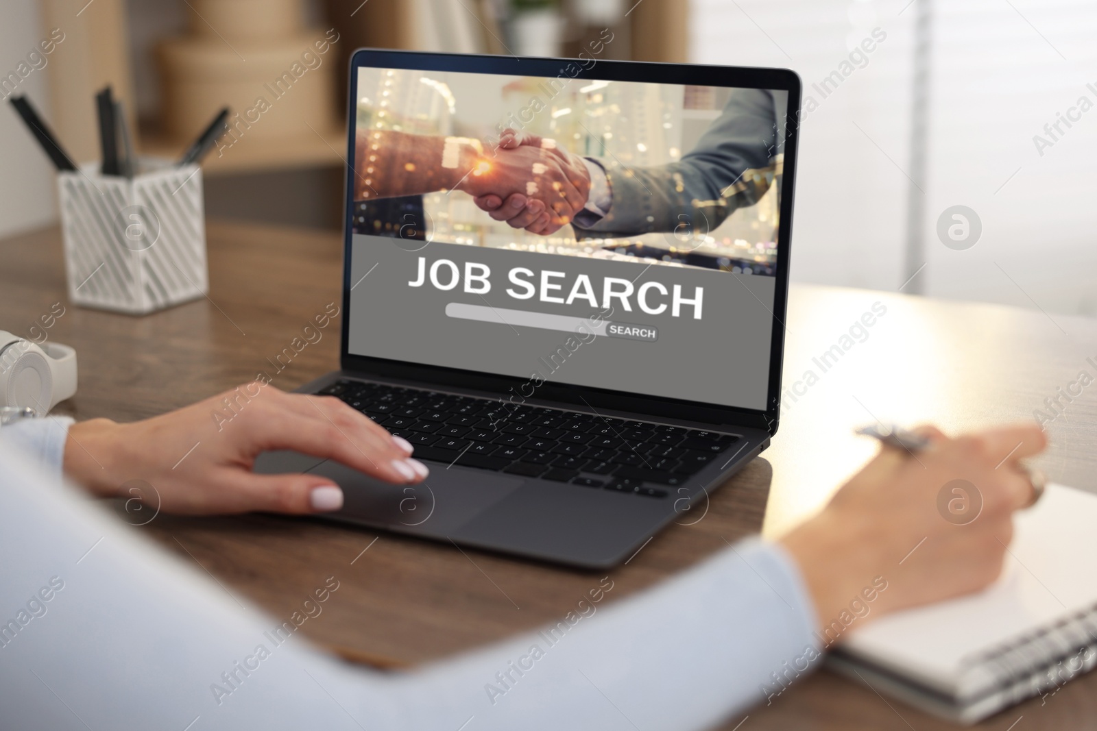 Image of Woman looking for job using employment website on laptop at home, closeup