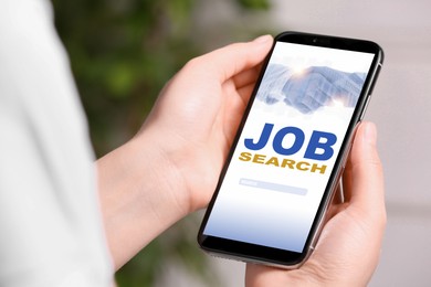 Image of Woman looking for job using employment website on mobile phone at home, closeup