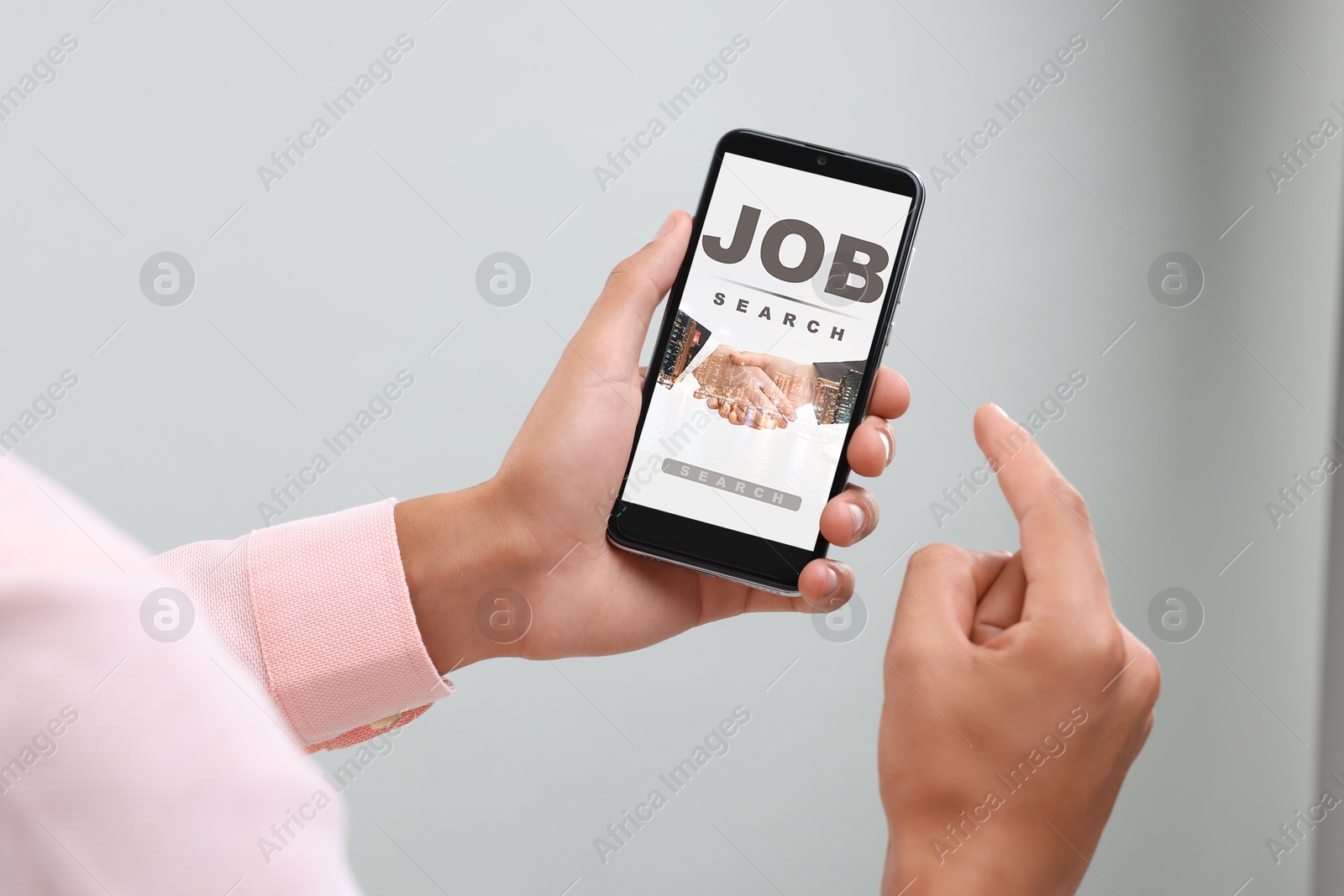 Image of Man looking for job using employment website on mobile phone indoors, closeup