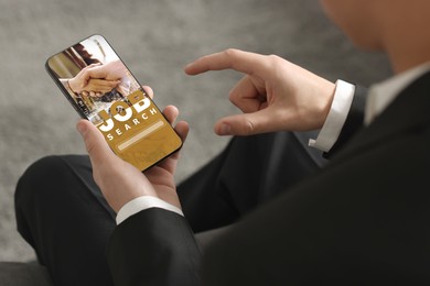 Image of Job search. Man using employment website on mobile phone indoors, closeup