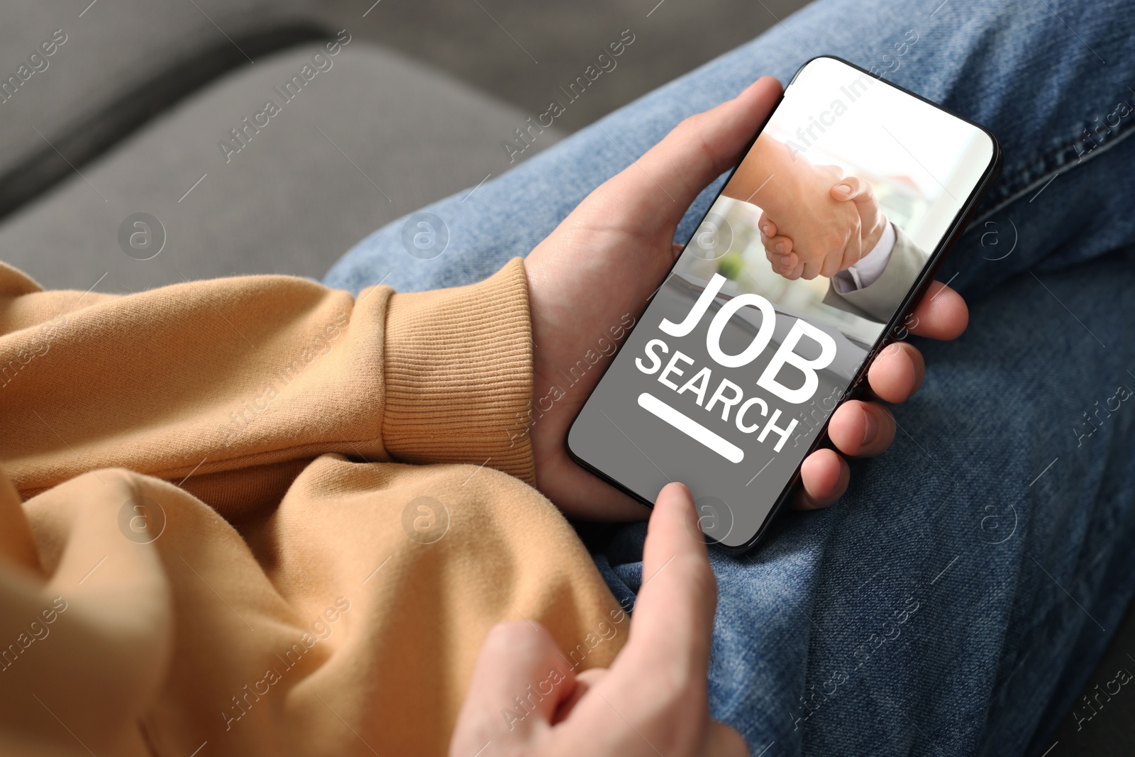 Image of Job search. Man using employment website on mobile phone at home, closeup