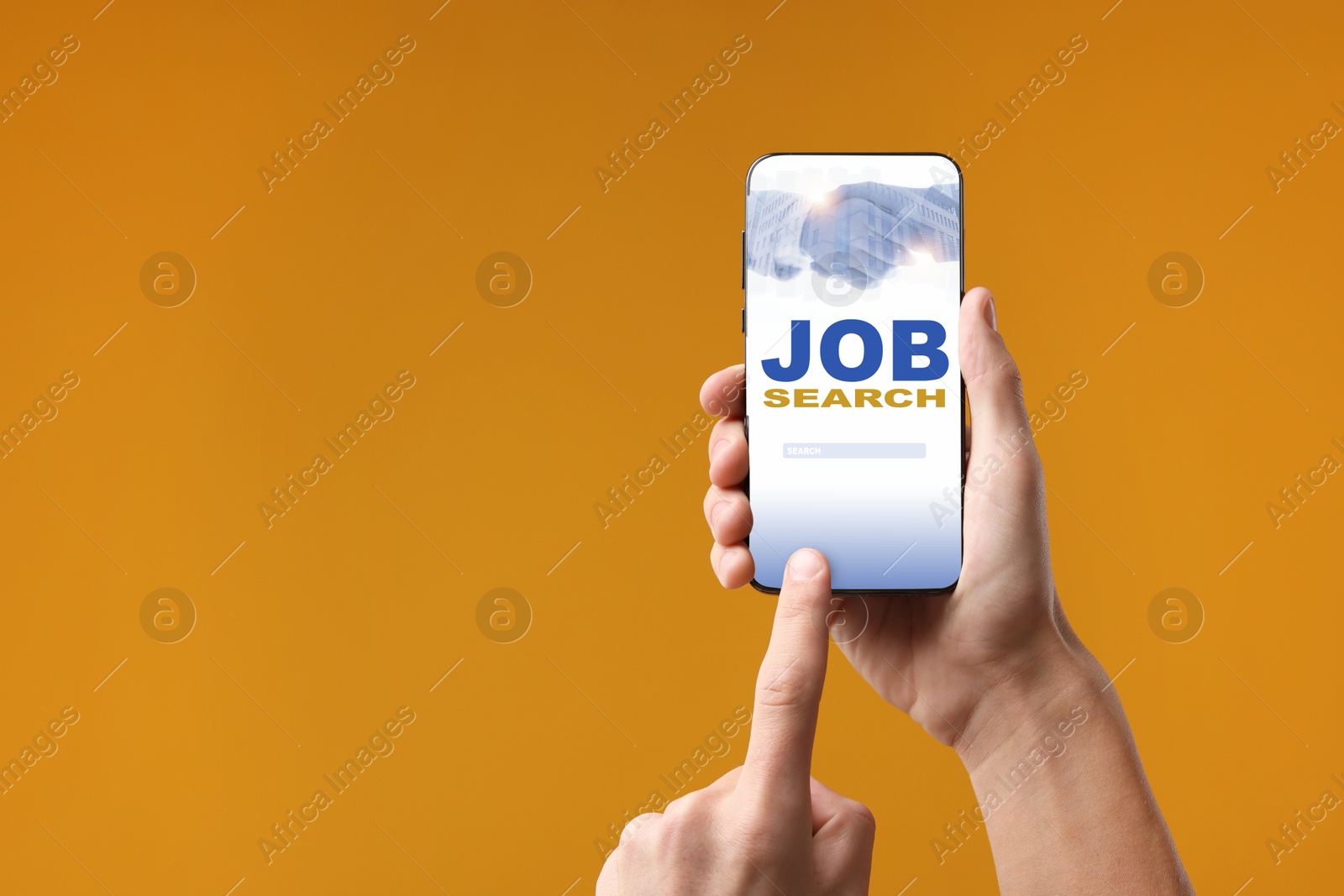 Image of Job search. Man using employment website on mobile phone on orange background, closeup