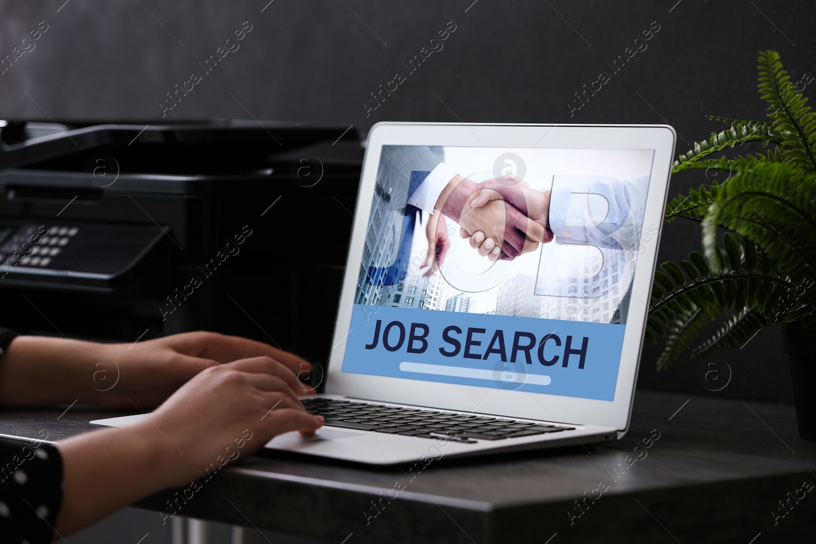 Image of Woman looking for job using employment website on laptop at home, closeup