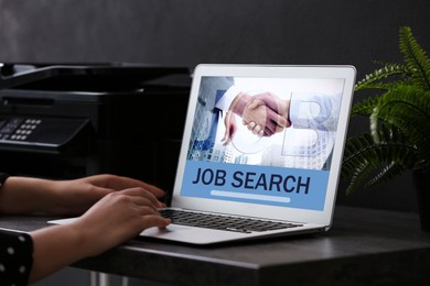 Image of Woman looking for job using employment website on laptop at home, closeup