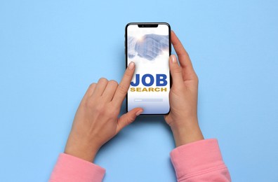 Image of Job search. Woman using employment website on mobile phone on light blue background, top view