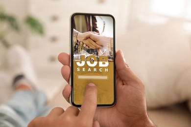 Image of Job search. Man using employment website on mobile phone at home, closeup