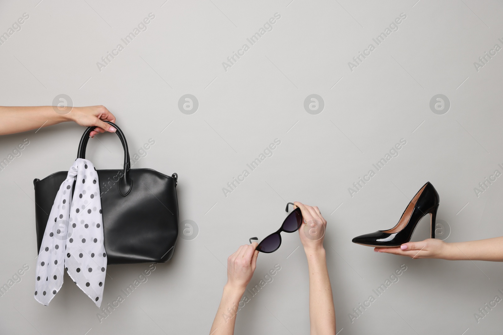 Photo of Women with stylish accessories and shoe on light grey background, closeup. Space for text