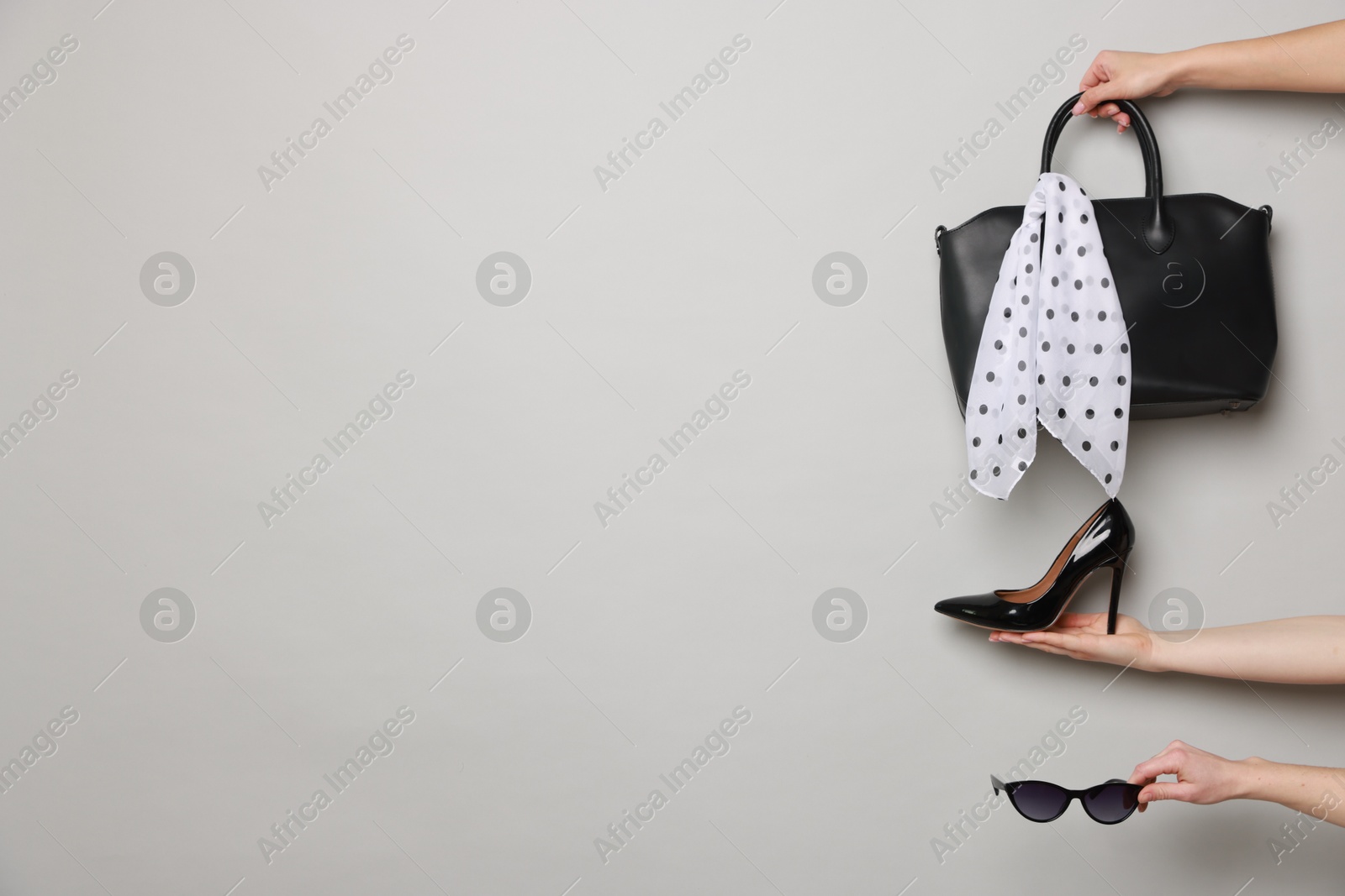 Photo of Women with stylish accessories and shoe on light grey background, closeup. Space for text