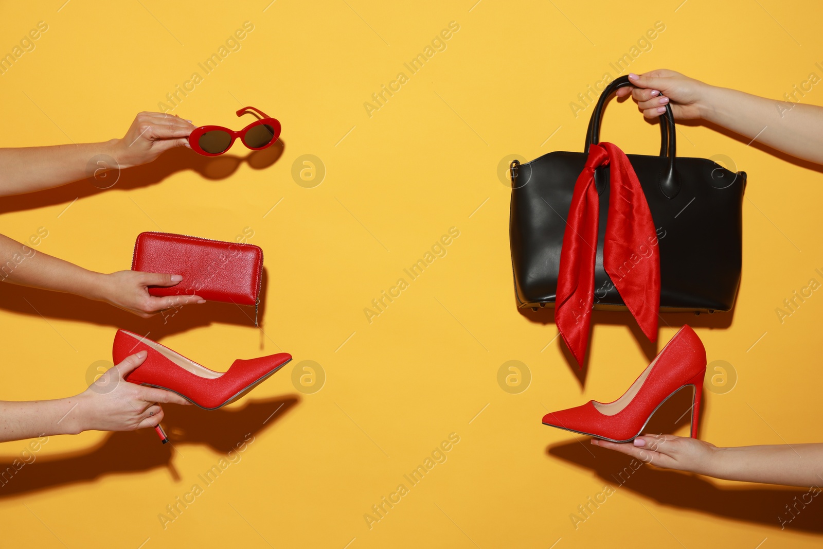 Photo of Women with stylish accessories and shoes on orange background, closeup. Space for text