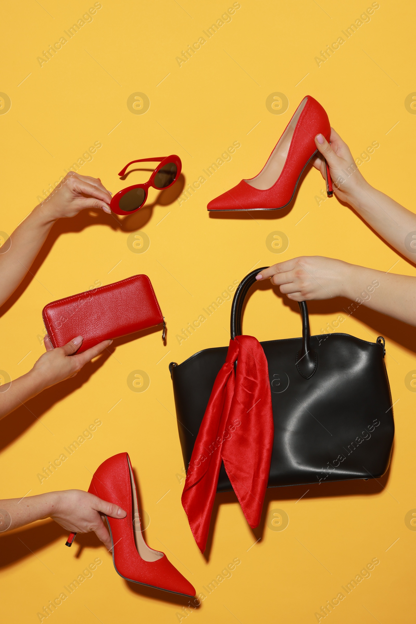 Photo of Women with stylish accessories and shoes on orange background, closeup