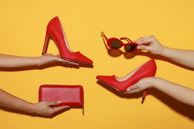 Photo of Women with stylish accessories and shoes on orange background, closeup