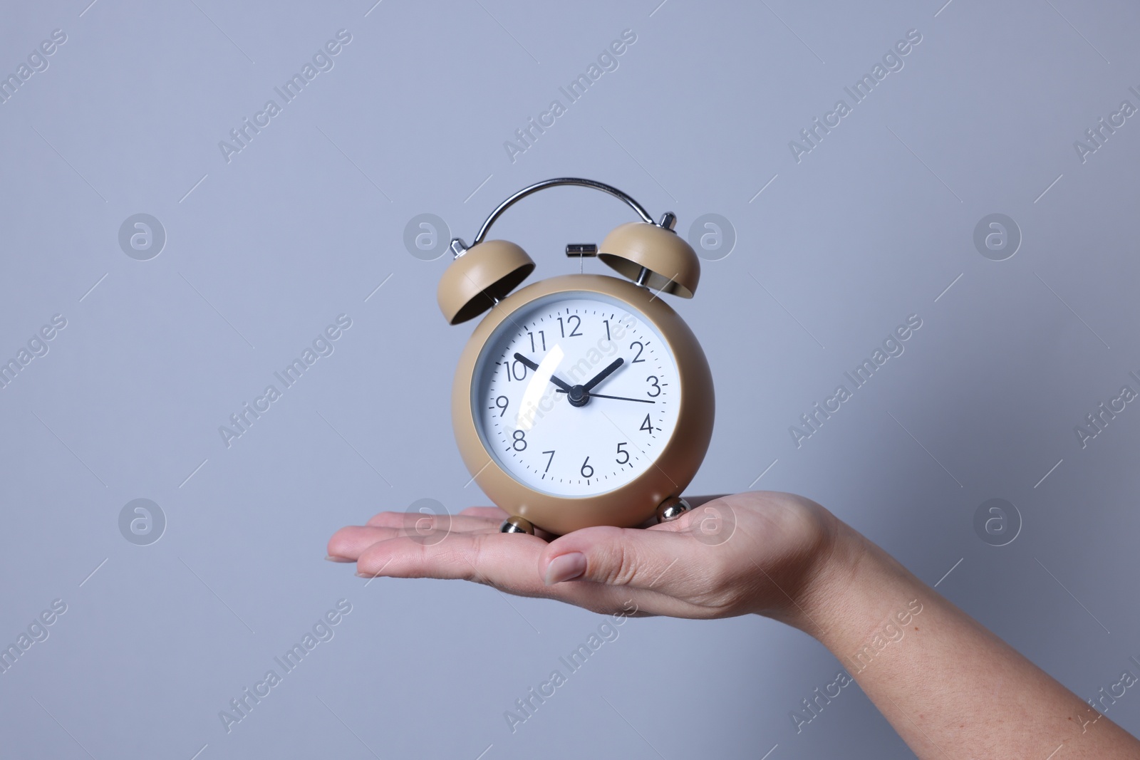 Photo of Woman with alarm clock on grey background, closeup