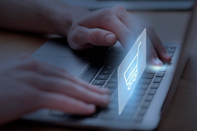 Image of Man shopping online using laptop, closeup. Illustration of shopping cart over device