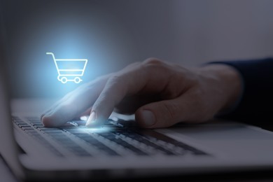 Image of Man shopping online using laptop, closeup. Illustration of shopping cart over device