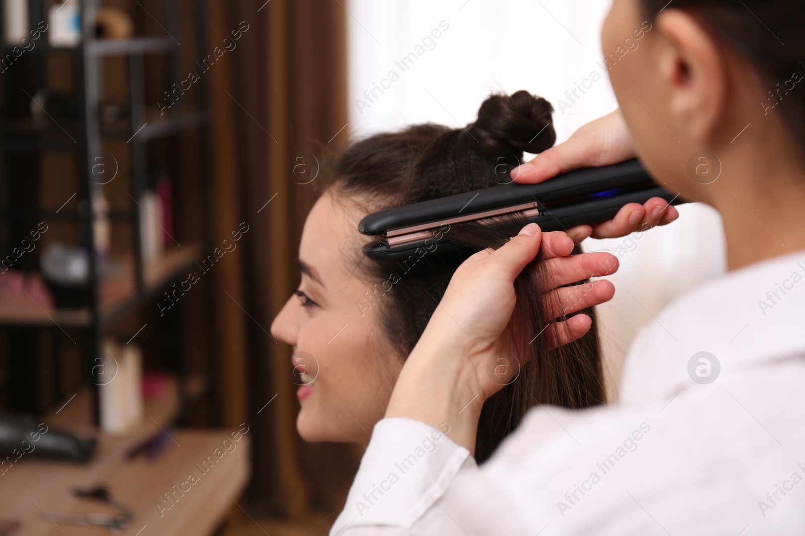 Photo of Stylist working with client in salon, making hairstyle