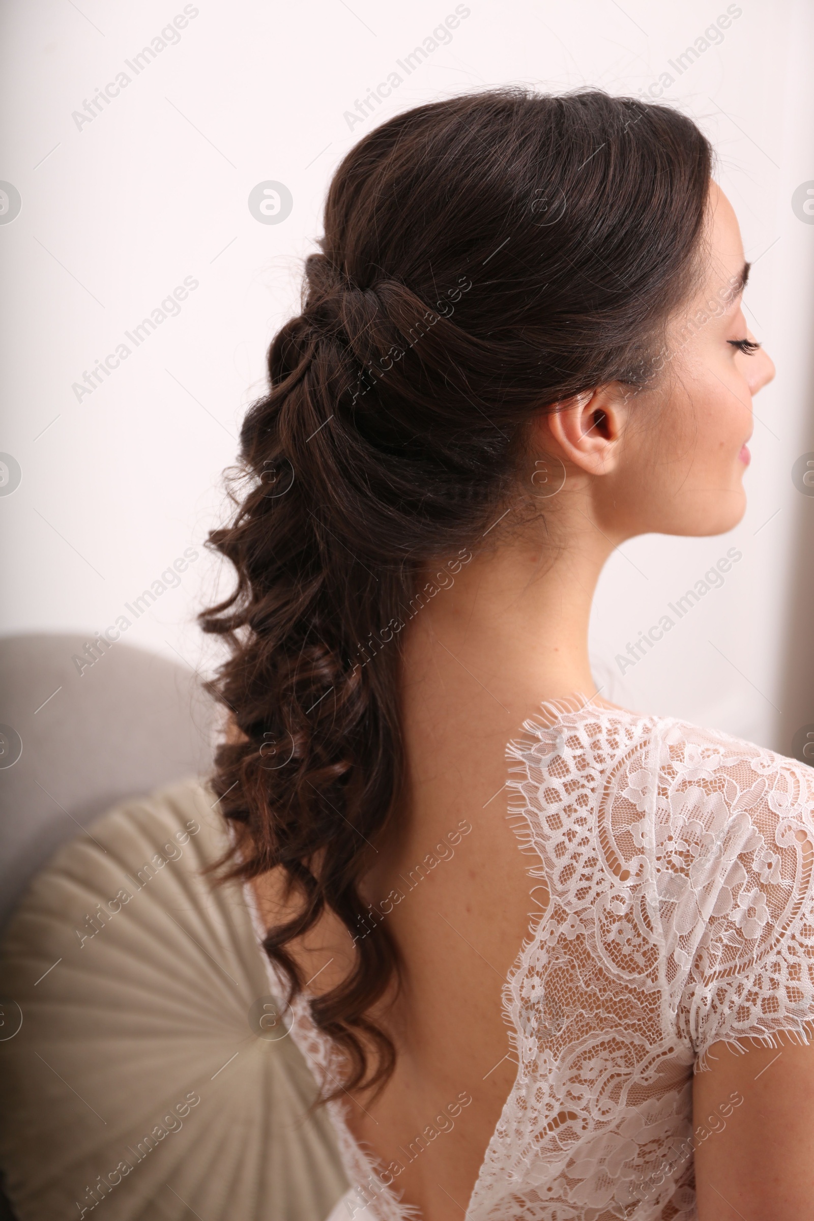 Photo of Beautiful young bride with wedding hairstyle indoors