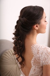 Photo of Beautiful young bride with wedding hairstyle indoors