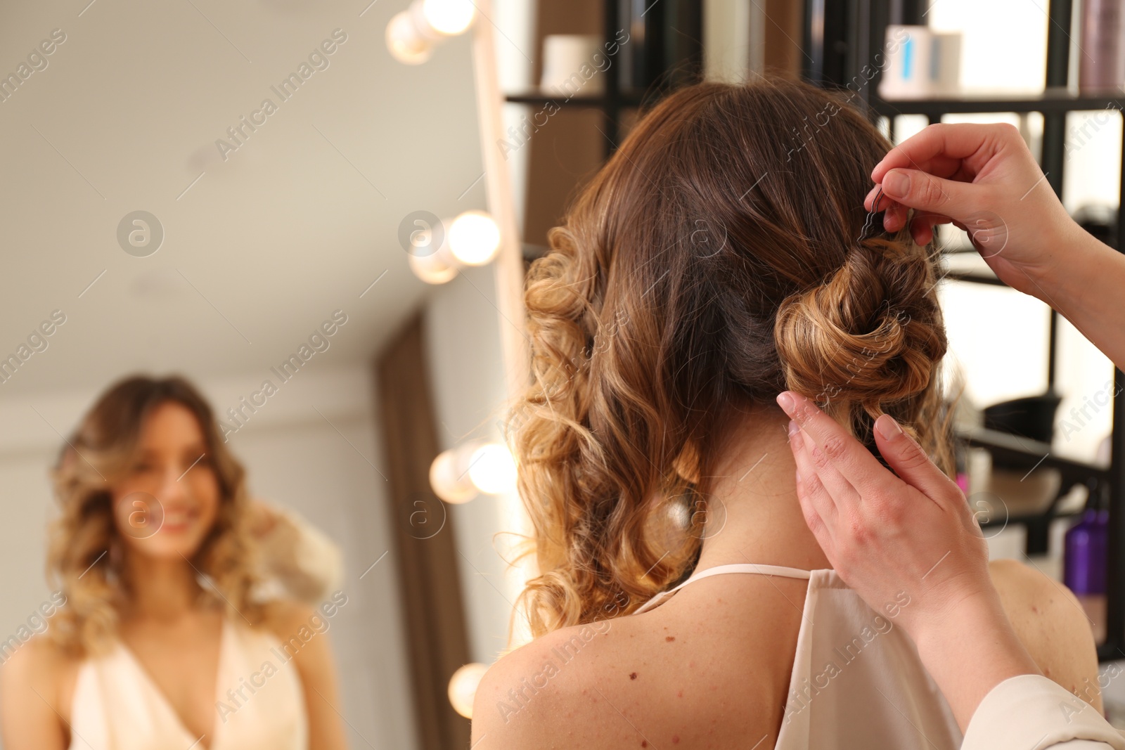 Photo of Stylist working with client in salon, making hairstyle