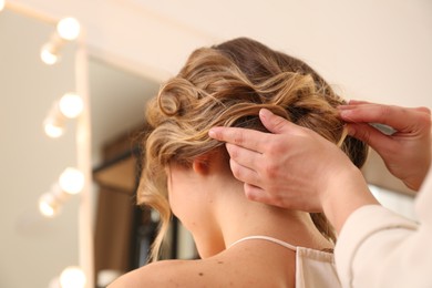 Photo of Stylist working with client in salon, making hairstyle