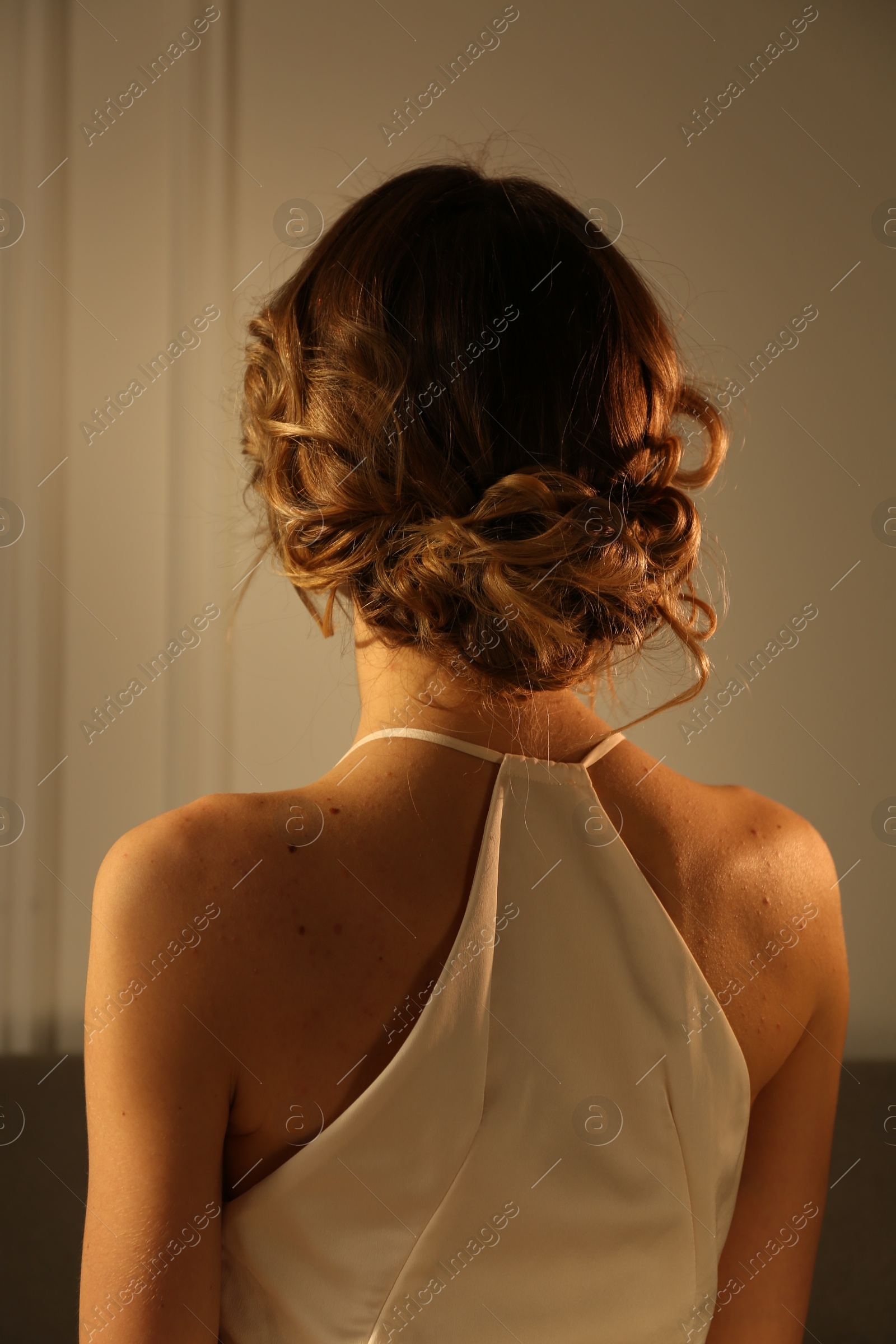 Photo of Elegant young woman with beautiful hairstyle indoors