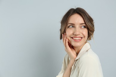 Photo of Young woman with beautiful hairstyle on light grey background. Space for text