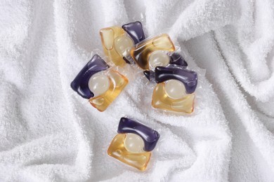 Photo of Laundry detergent capsules on white towel, closeup