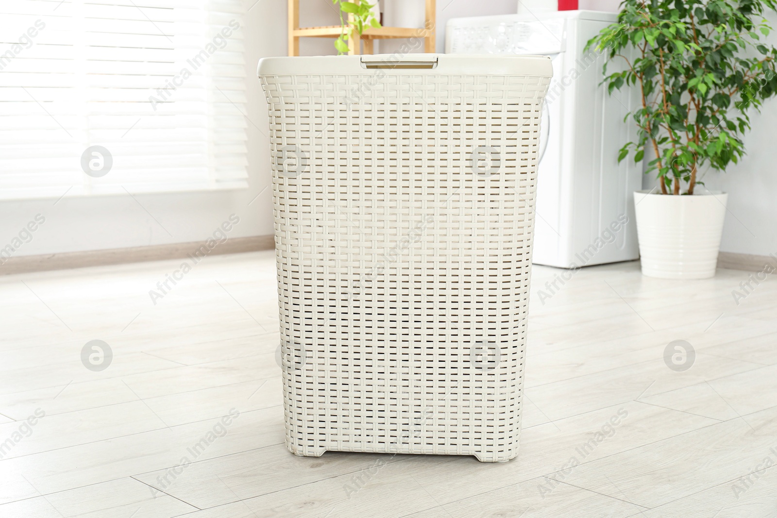 Photo of Wicker laundry basket on floor in bathroom