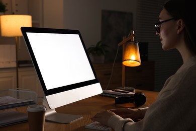 Photo of Woman working on computer at wooden table in office