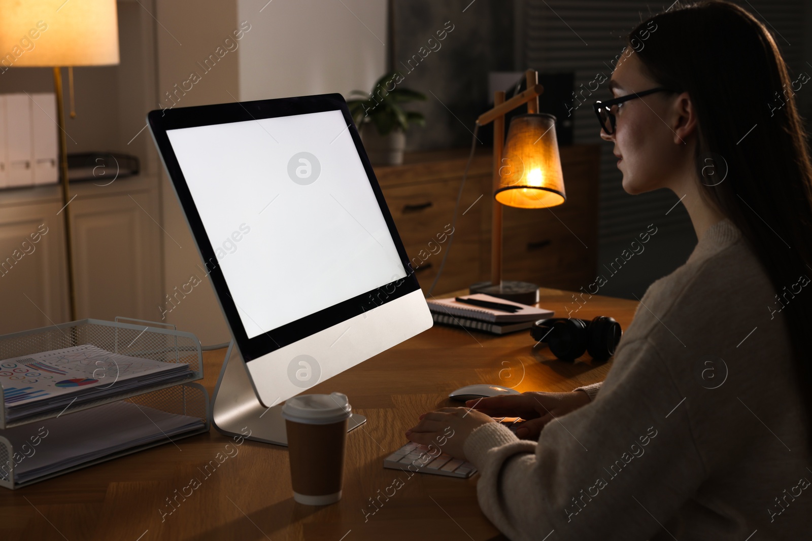 Photo of Woman working on computer at wooden table in office