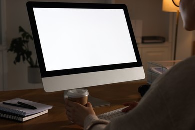 Photo of Woman working on computer at wooden table in office, closeup