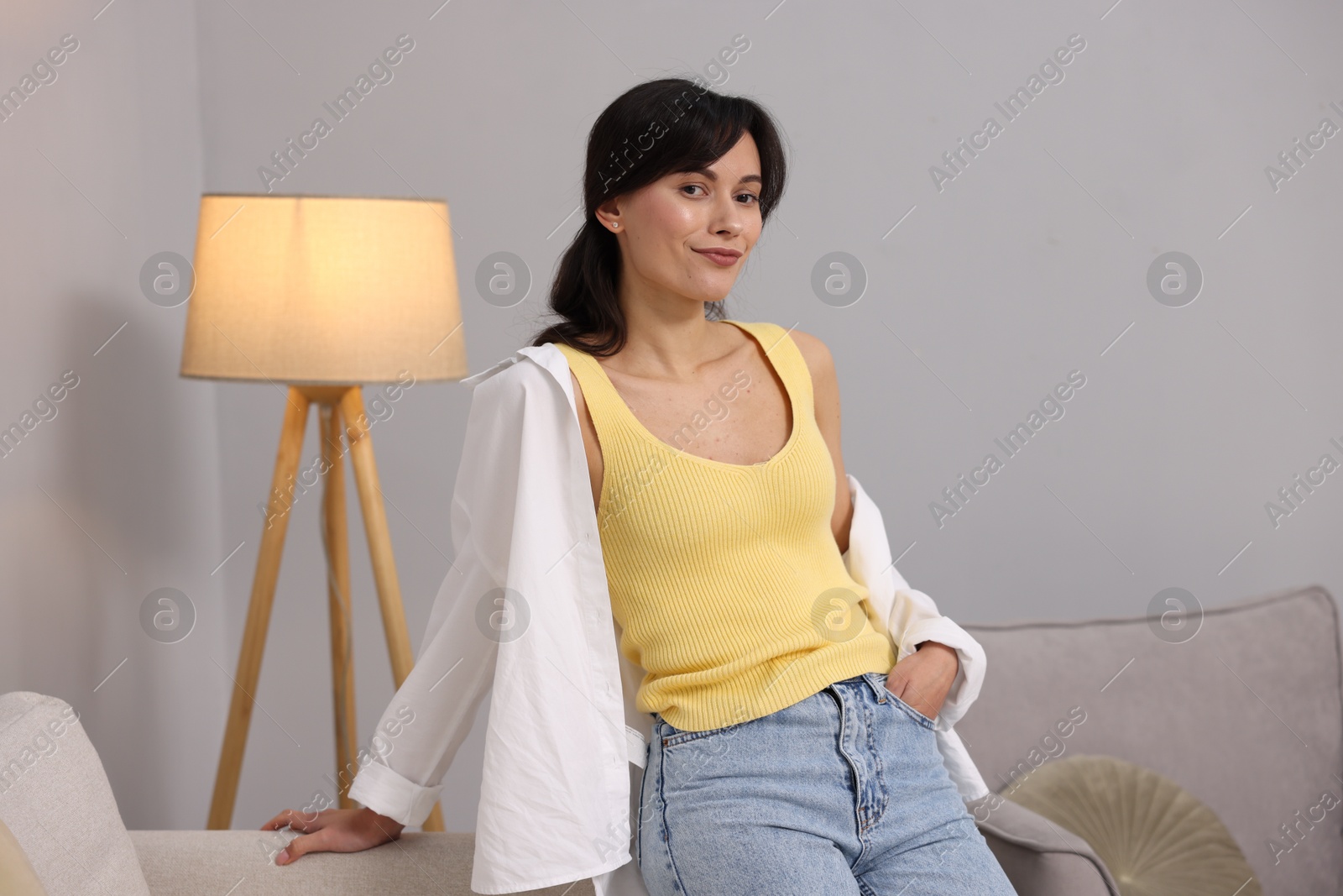 Photo of Portrait of beautiful young woman near light grey wall indoors