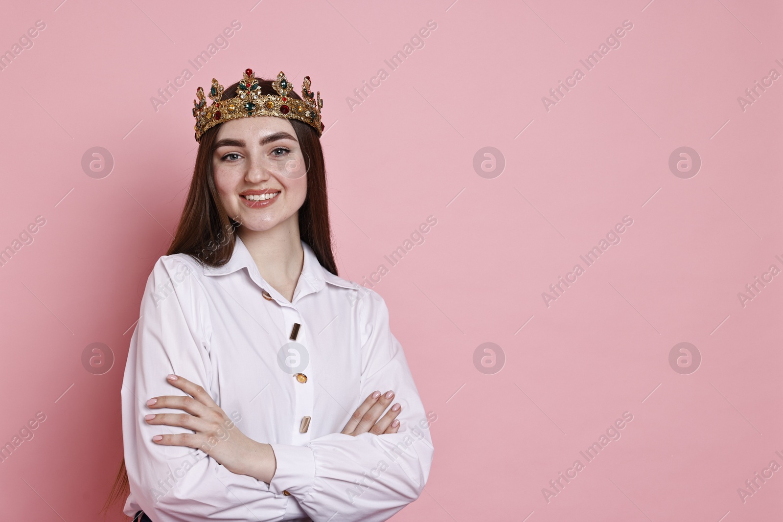 Photo of Happy woman in elegant crown on pink background. Space for text