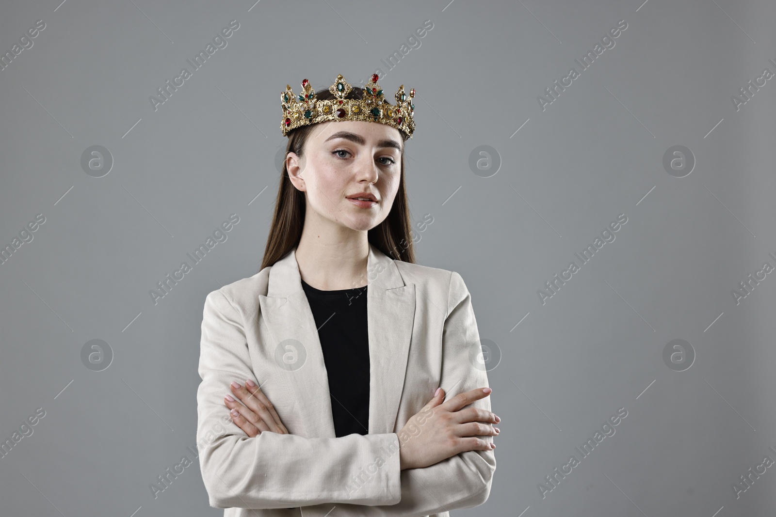 Photo of Businesswoman in elegant crown on grey background