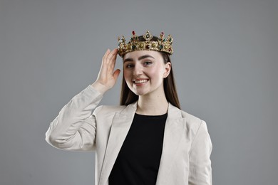 Photo of Happy businesswoman in elegant crown on grey background