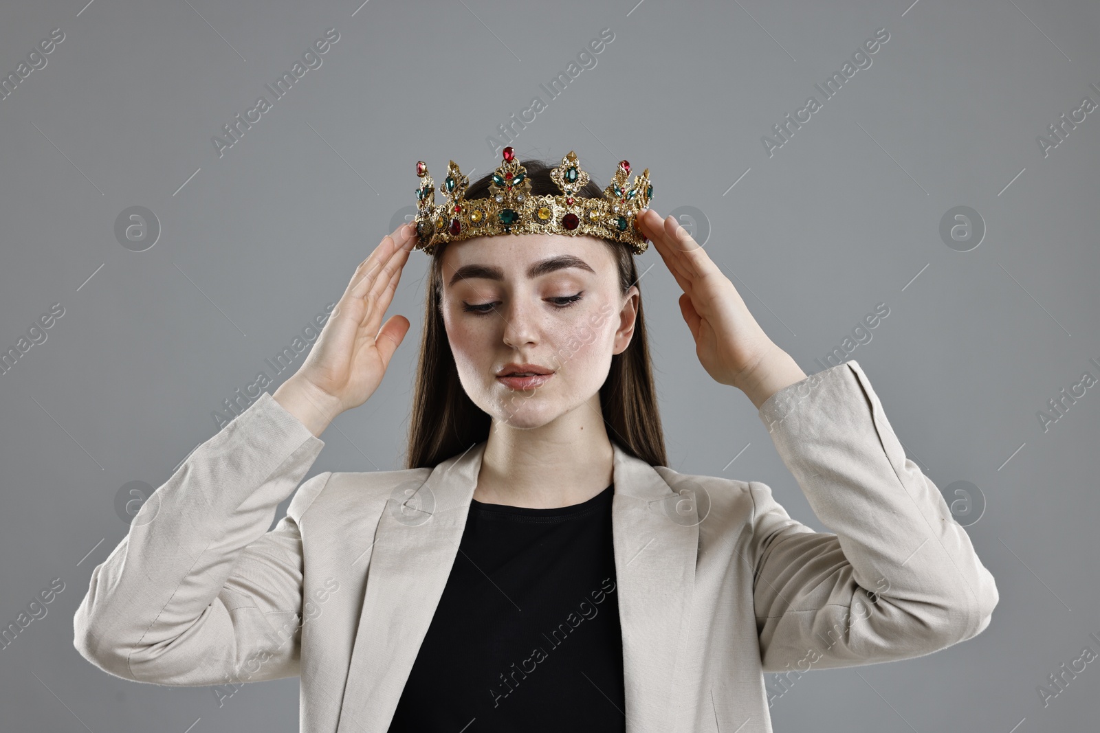 Photo of Businesswoman in elegant crown on grey background