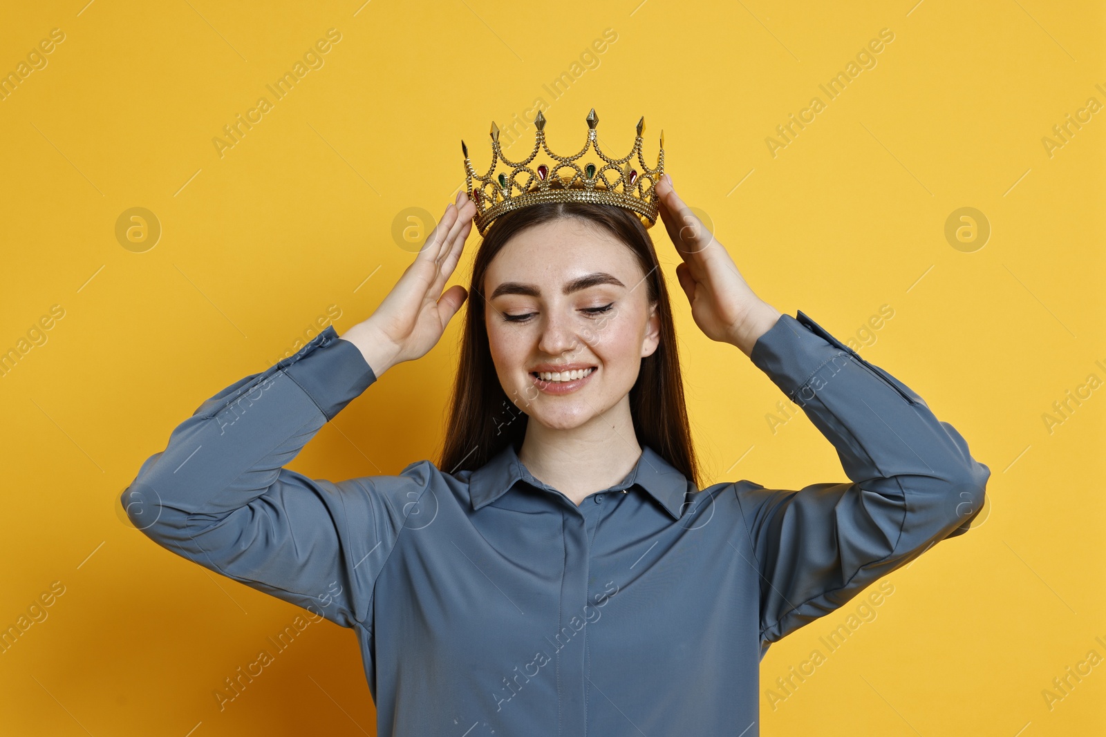 Photo of Happy woman in elegant crown on yellow background