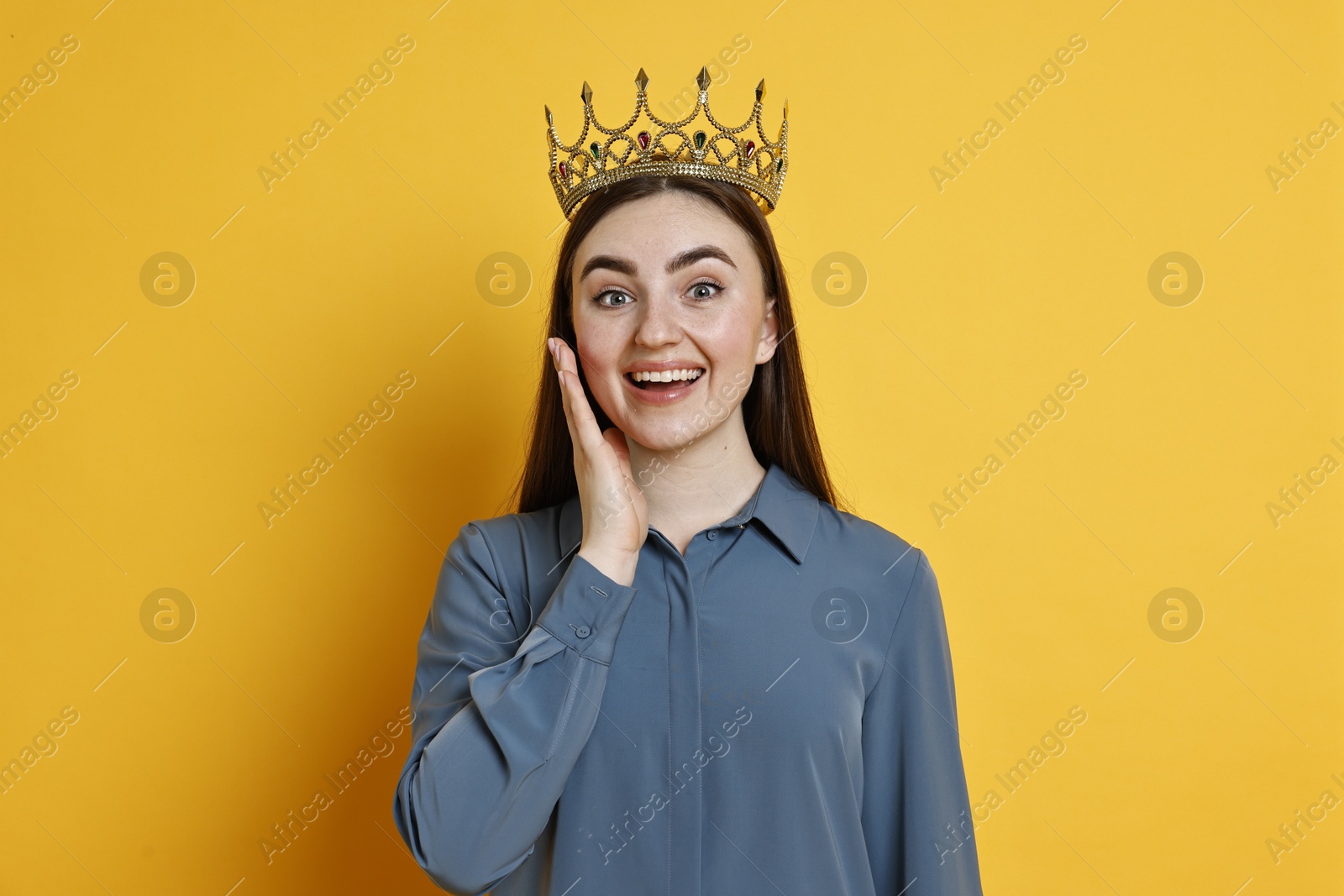 Photo of Happy woman in elegant crown on yellow background