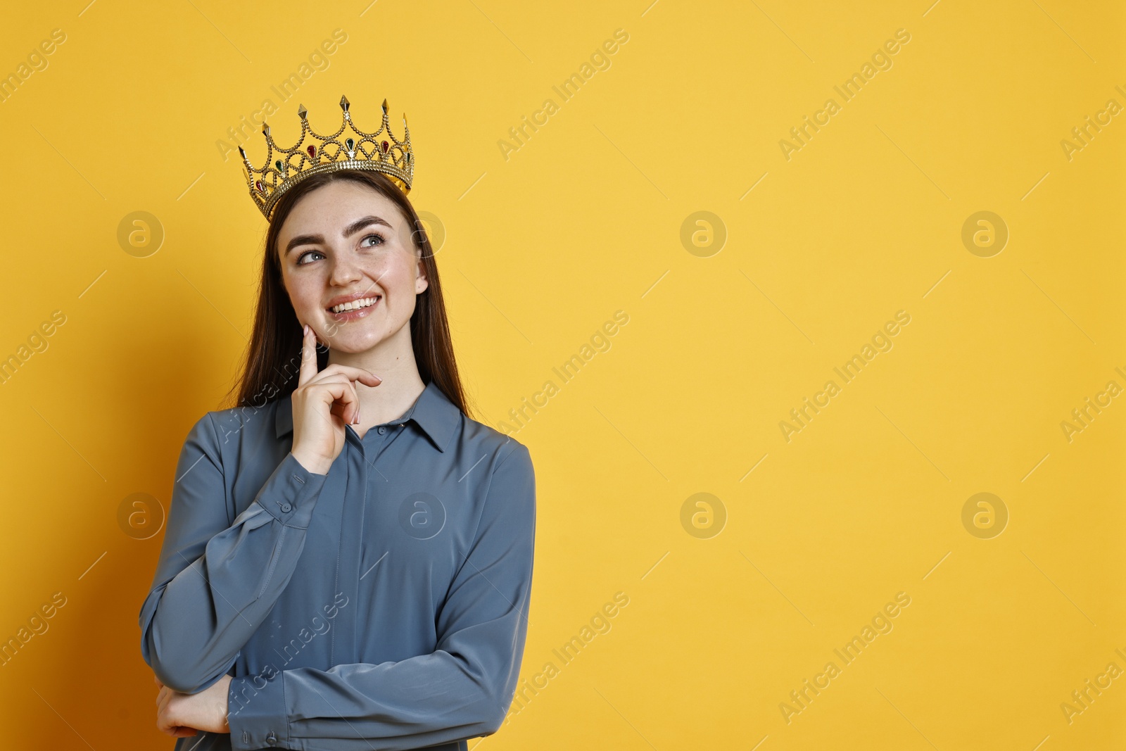 Photo of Happy woman in elegant crown on yellow background. Space for text