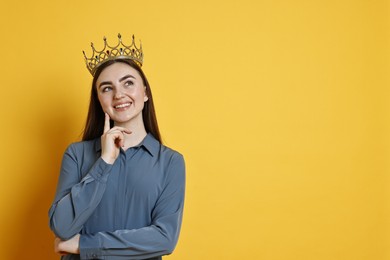 Photo of Happy woman in elegant crown on yellow background. Space for text